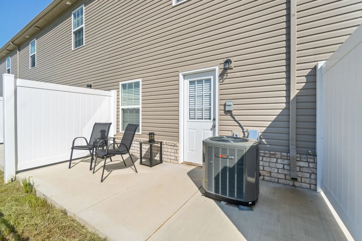 A casual patio area with comfortable chairs and a doorway leading inside, offering a seamless connection between indoor comfort and outdoor relaxation. The space is ideal for enjoying a coffee in the morning sun or quiet evening conversations.