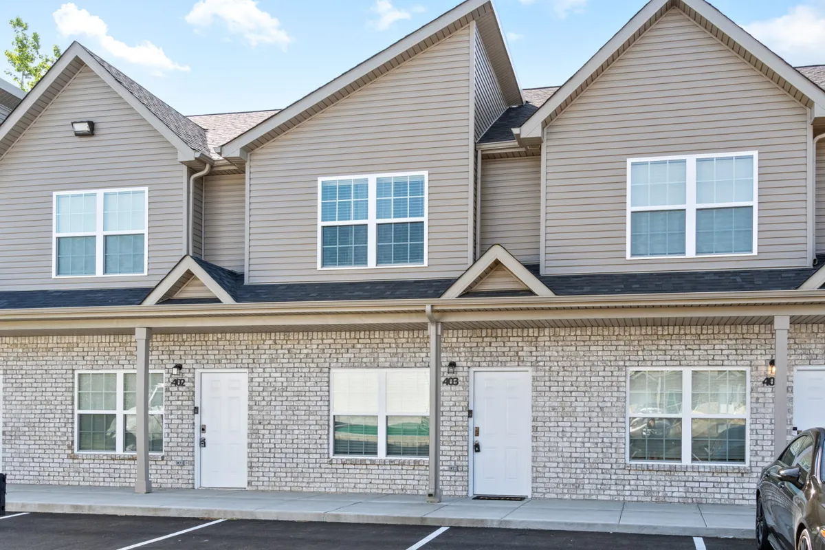 This exterior image features a welcoming stone facade with symmetrical windows and clean architectural lines. The scene radiates a sense of arrival and showcases the building in a way that suggests comfort and family-friendly appeal. The front area is set up to evoke relaxation and outdoor leisure, hinting at the ease of returning to a restful home after city adventures.